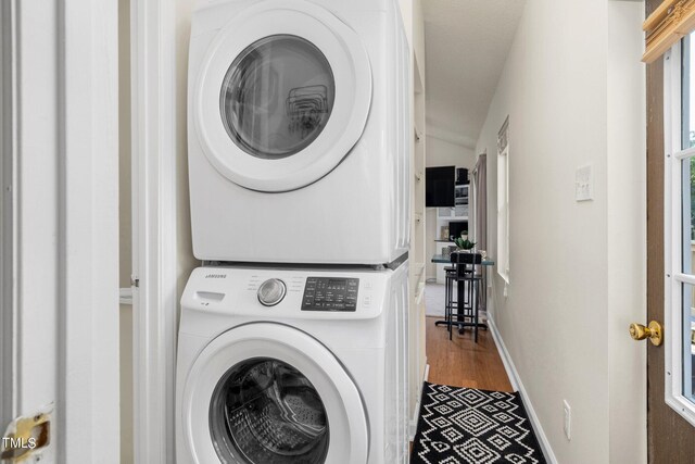 washroom featuring hardwood / wood-style floors and stacked washer and clothes dryer