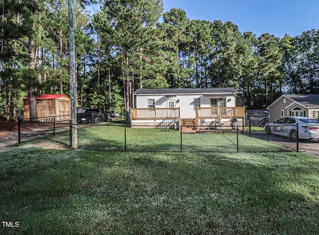 view of front of home featuring a front yard, a deck, and a shed