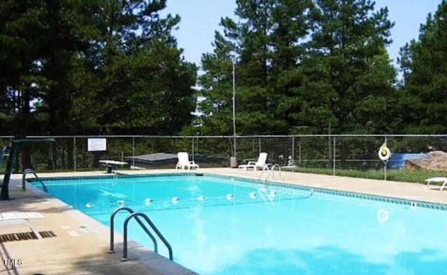 view of swimming pool featuring a diving board