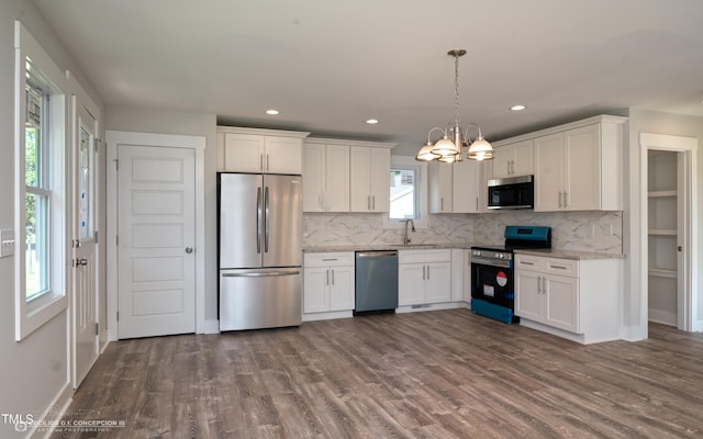 kitchen with appliances with stainless steel finishes, wood-type flooring, and white cabinetry