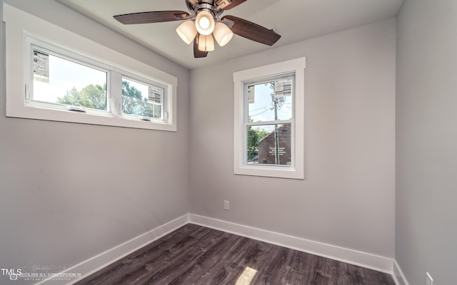 empty room featuring ceiling fan, dark hardwood / wood-style floors, and plenty of natural light