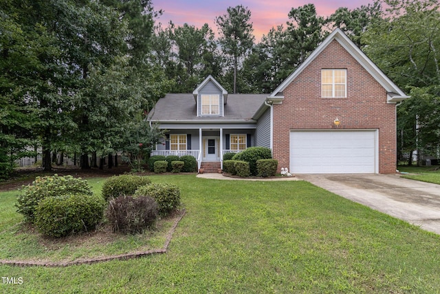 view of front of house featuring a garage, a porch, and a yard