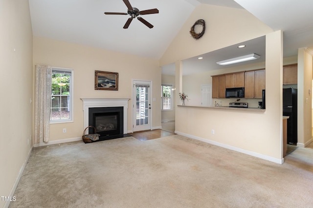 unfurnished living room featuring high vaulted ceiling, light colored carpet, and a healthy amount of sunlight