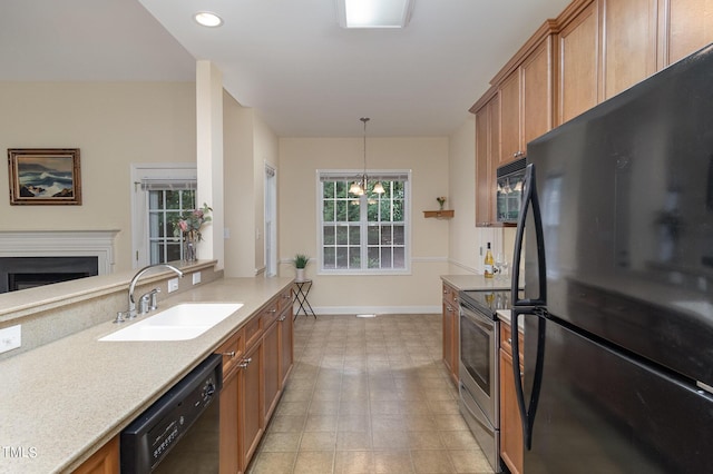 kitchen with an inviting chandelier, decorative light fixtures, sink, and black appliances