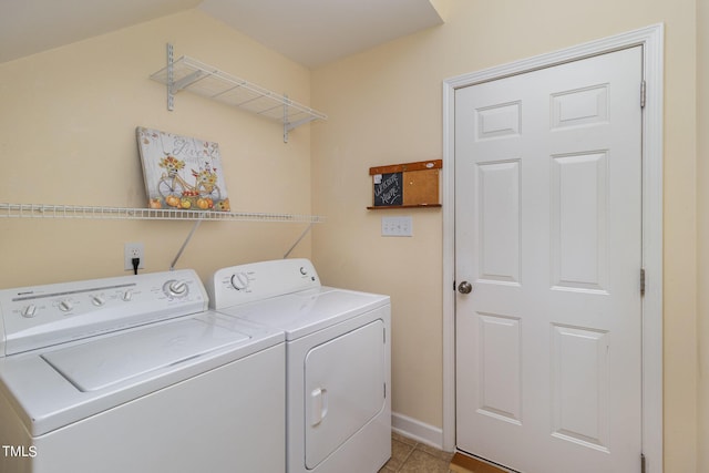 laundry room featuring washer and clothes dryer and light tile patterned floors