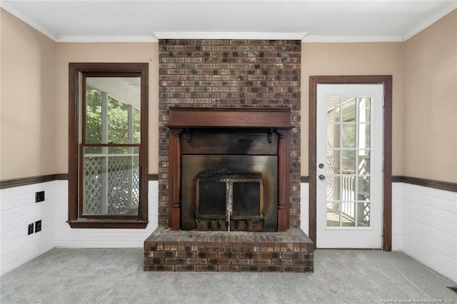 unfurnished living room featuring a brick fireplace, carpet floors, and ornamental molding