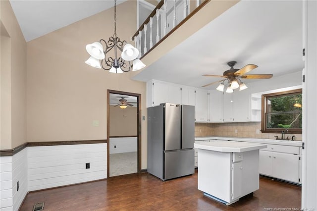 kitchen featuring pendant lighting, stainless steel fridge, a kitchen island, and white cabinetry