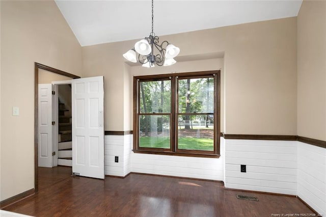 empty room with dark wood-type flooring, an inviting chandelier, and lofted ceiling