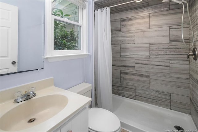 bathroom featuring a shower with shower curtain, vanity, and toilet