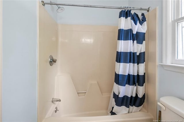 bathroom with shower / bath combination with curtain and toilet