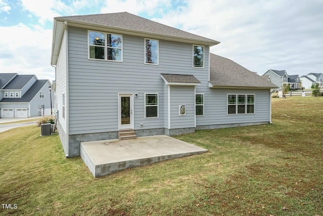 rear view of house with cooling unit, a yard, and a patio area