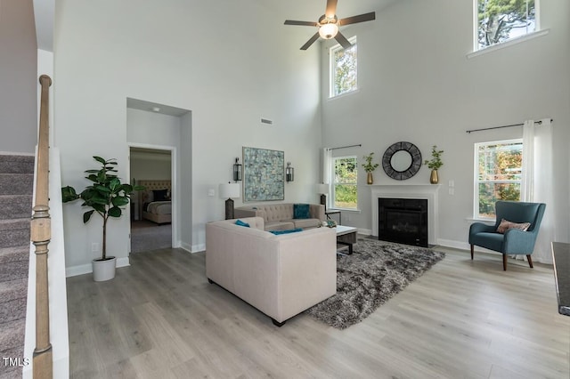 living room featuring ceiling fan, plenty of natural light, and light wood-type flooring