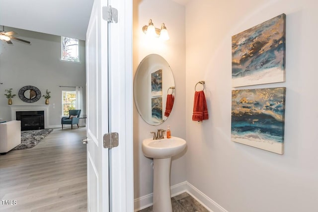 bathroom featuring hardwood / wood-style flooring, ceiling fan, and a towering ceiling