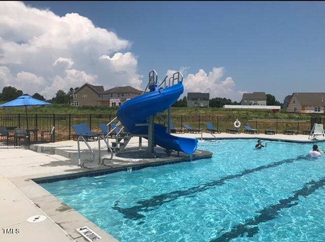 view of pool featuring a water slide and a patio area