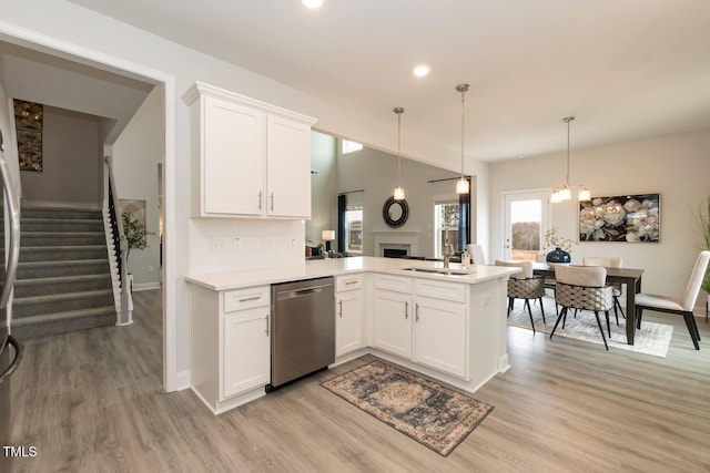 kitchen with white cabinetry, pendant lighting, stainless steel dishwasher, and kitchen peninsula