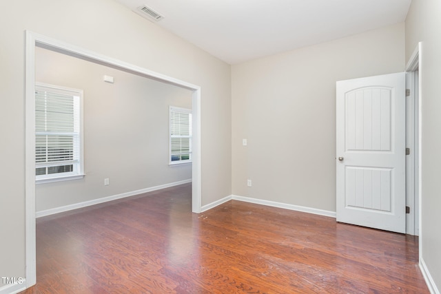 unfurnished room featuring dark hardwood / wood-style flooring