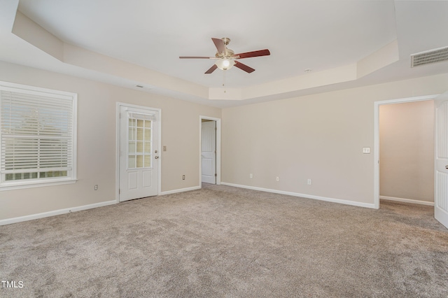 unfurnished room with carpet, ceiling fan, and a raised ceiling