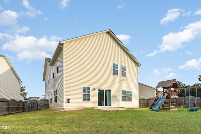 rear view of property featuring a playground and a yard