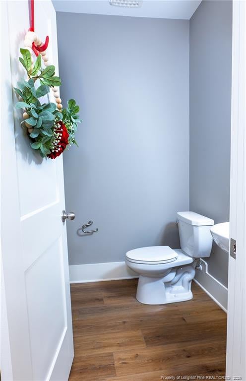 bathroom featuring hardwood / wood-style floors and toilet