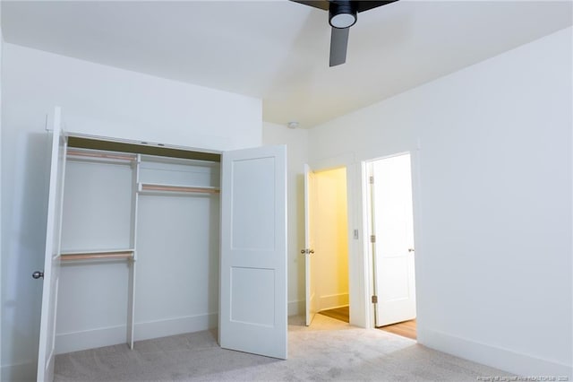 unfurnished bedroom featuring light carpet, a closet, and ceiling fan