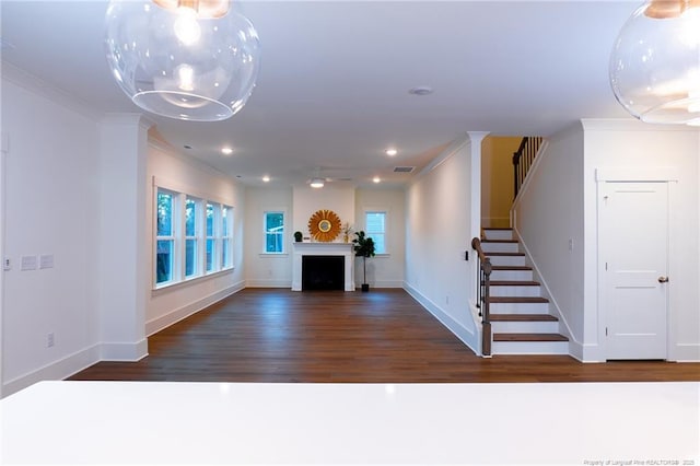 interior space featuring a healthy amount of sunlight, dark hardwood / wood-style flooring, and ornamental molding