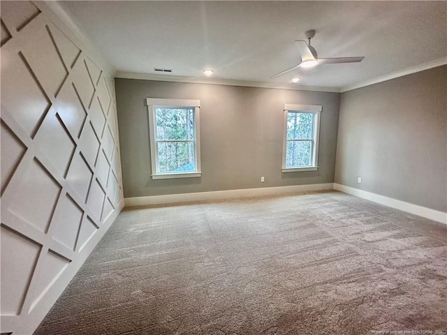 carpeted spare room with crown molding, ceiling fan, and a healthy amount of sunlight