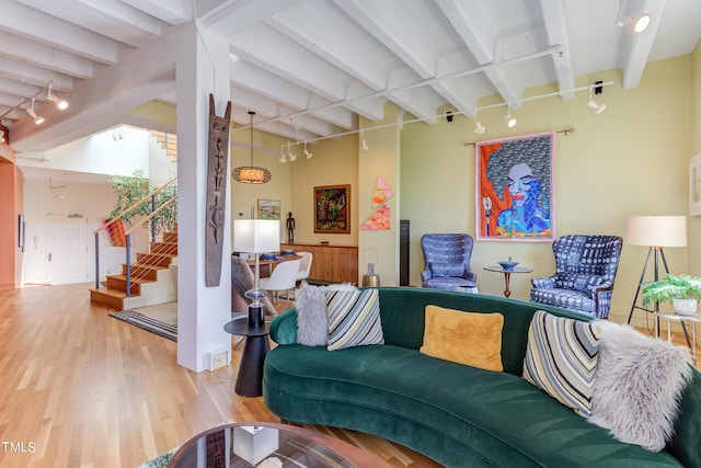 living room featuring wood-type flooring, rail lighting, and beamed ceiling