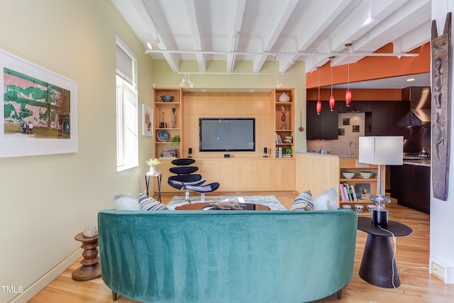 living room featuring beam ceiling and light wood-type flooring