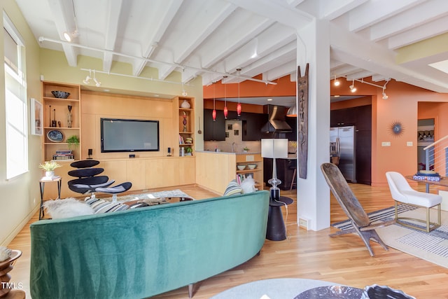 living room featuring beamed ceiling, light wood-type flooring, and track lighting