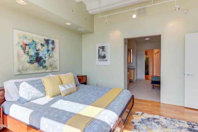 bedroom with hardwood / wood-style floors and rail lighting