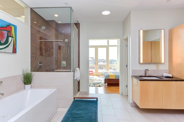 bathroom with shower with separate bathtub, sink, and tile patterned flooring