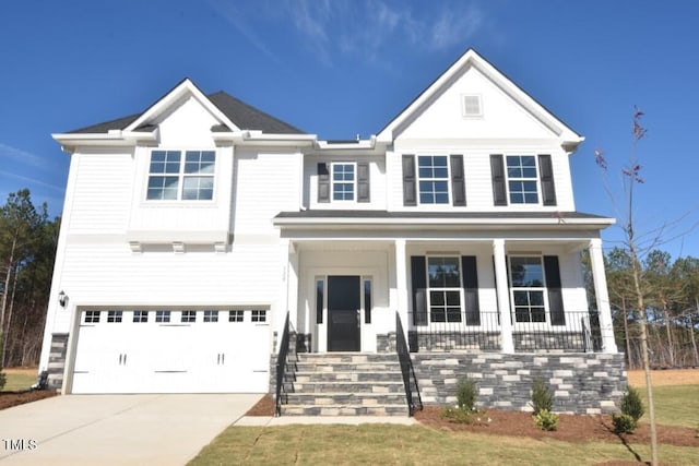 view of front of home featuring a front yard, a porch, and a garage