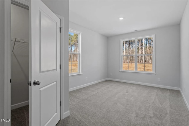 unfurnished bedroom with carpet floors, multiple windows, and baseboards