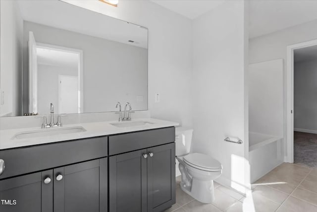 full bath featuring double vanity, a sink, toilet, and tile patterned floors