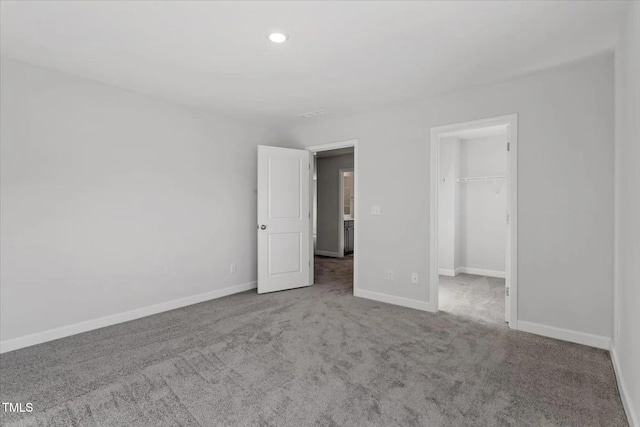 unfurnished bedroom featuring recessed lighting, carpet floors, baseboards, a spacious closet, and a closet