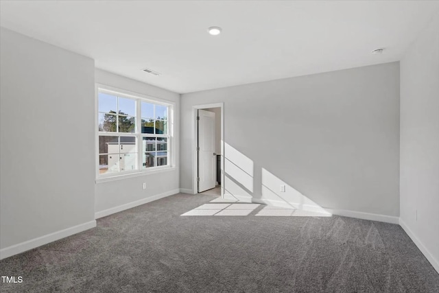 spare room featuring visible vents, baseboards, and carpet flooring