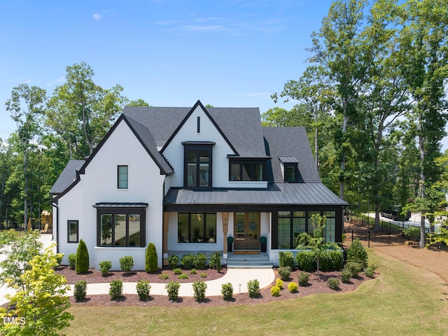 modern farmhouse with covered porch and a front yard