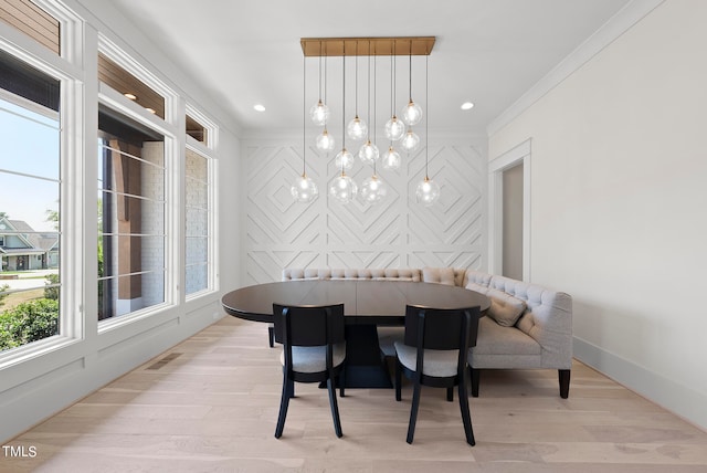 dining area featuring plenty of natural light, crown molding, and light hardwood / wood-style floors