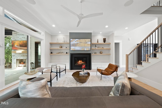 living room with ceiling fan, light hardwood / wood-style flooring, ornamental molding, and built in features