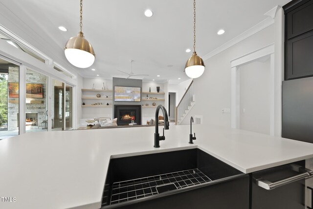 kitchen featuring sink, ornamental molding, pendant lighting, and a kitchen island