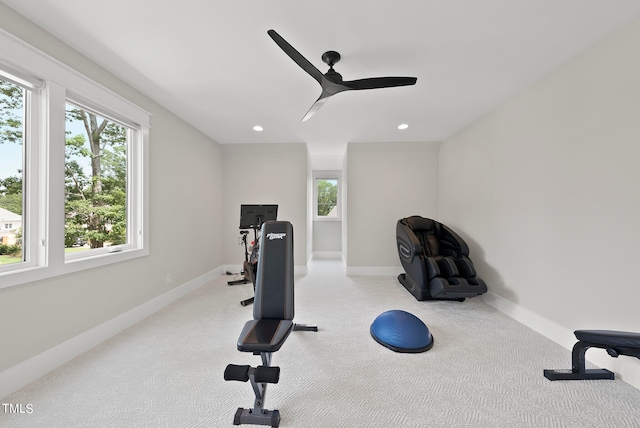 exercise area with ceiling fan and light colored carpet