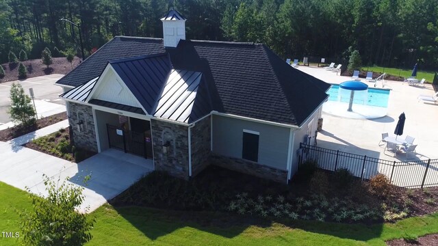 back of property featuring a yard, a patio, and a fenced in pool