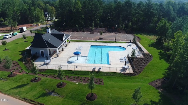 view of pool with a patio area and a lawn