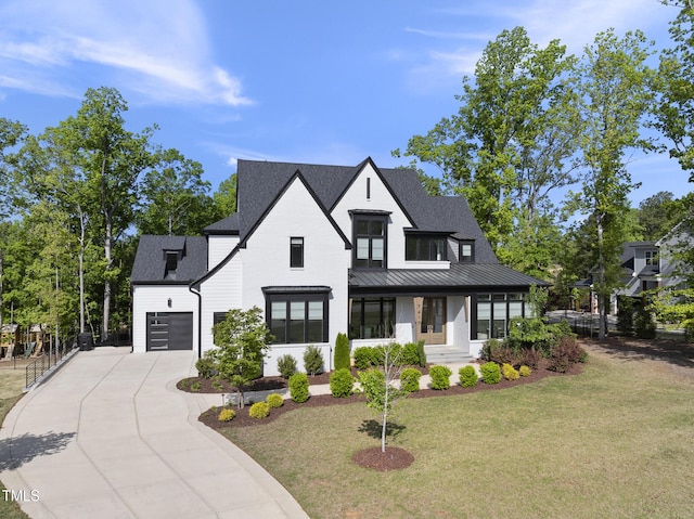 modern farmhouse style home with roof with shingles, a front yard, and concrete driveway