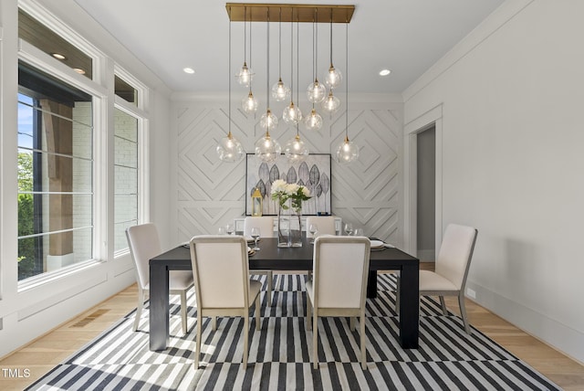 dining room with light wood-type flooring, a healthy amount of sunlight, baseboards, and visible vents