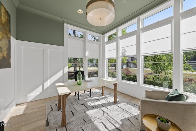 sunroom / solarium with a decorative wall, wood finished floors, and recessed lighting