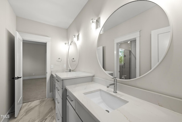 full bath with two vanities, marble finish floor, baseboards, and a sink
