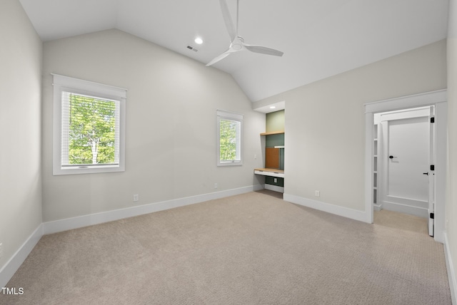 interior space with lofted ceiling, baseboards, carpet, and ceiling fan