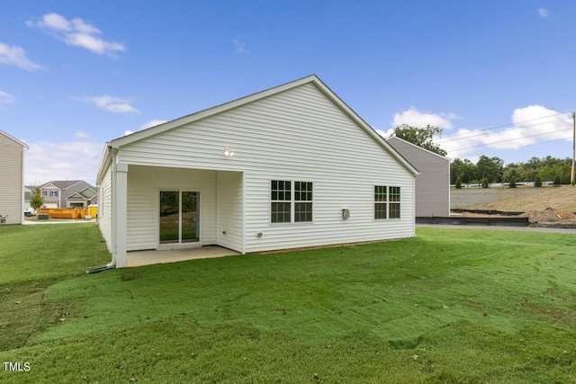 back of property featuring a patio and a yard