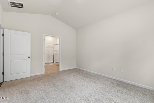 unfurnished bedroom with light carpet, connected bathroom, and vaulted ceiling